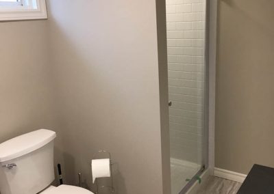 White Toilet and Beige Basement Bathroom
