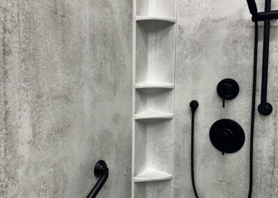 Concrete shower walls, with black shower fixtures and faucets
