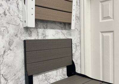 A closer view of shower seats that are available for safety and accessibility, mounted onto the wall of a shower.