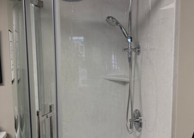 A closer view of the custom round cornered shower with clear glass doors in a bathroom.