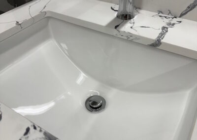Another angle of the white and black marble patterned sink with a reflective silver faucet.