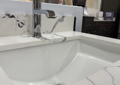 Another view of the white and black marble patterned sink with a reflective silver faucet.